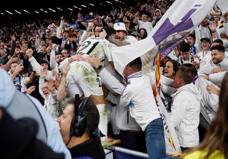 Brahim Diaz jumps into the crowd to celebrate scoring