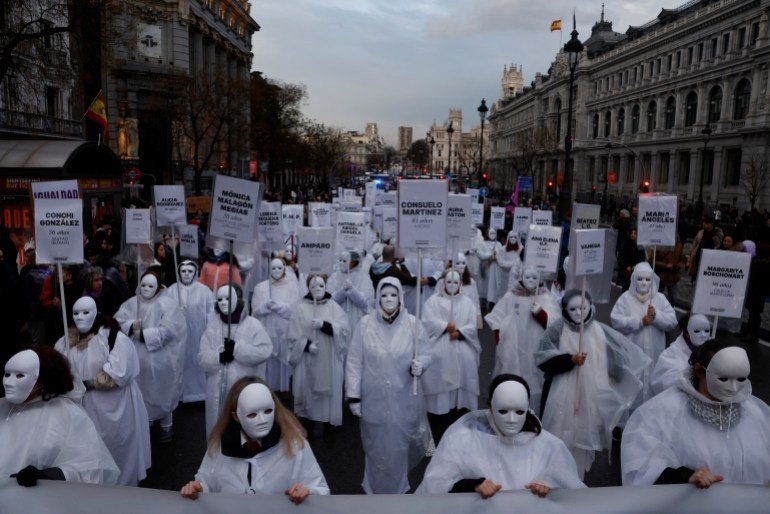 Women wearing masks hold signs with the names of those who, according to them, are victims of gender-based violence, during a demonstration to mark International Women's Day in Madrid, Spain, March 8, 2025. REUTERS/Susana Vera