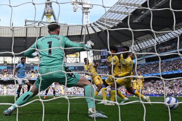 Manchester City's Egyptian striker #07 Omar Marmoush (R) scores their second goal past Crystal Palace's English goalkeeper #01 Dean Henderson (L) during the English Premier League football match between Manchester City and Crystal Palace at the Etihad Stadium in Manchester, north west England, on April 12, 2025. (Photo by Paul ELLIS / AFP) / RESTRICTED TO EDITORIAL USE. NO USE WITH UNAUTHORIZED AUDIO, VIDEO, DATA, FIXTURE LISTS, CLUB/LEAGUE LOGOS OR 'LIVE' SERVICES. ONLINE IN-MATCH USE LIMITED TO 120 IMAGES. AN ADDITIONAL 40 IMAGES MAY BE USED IN EXTRA TIME. NO VIDEO EMULATION. SOCIAL MEDIA IN-MATCH USE LIMITED TO 120 IMAGES. AN ADDITIONAL 40 IMAGES MAY BE USED IN EXTRA TIME. NO USE IN BETTING PUBLICATIONS, GAMES OR SINGLE CLUB/LEAGUE/PLAYER PUBLICATIONS. /