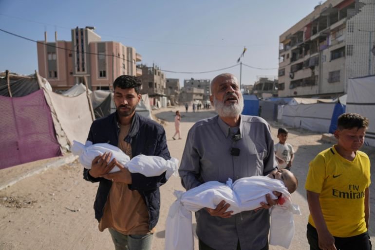 Abdel Rahman Sinwar, left, carries the body of his infant son, Yahia Sinwar, while the child's grandfather carries the body of his one-year-old grandson, Seif Sinwar