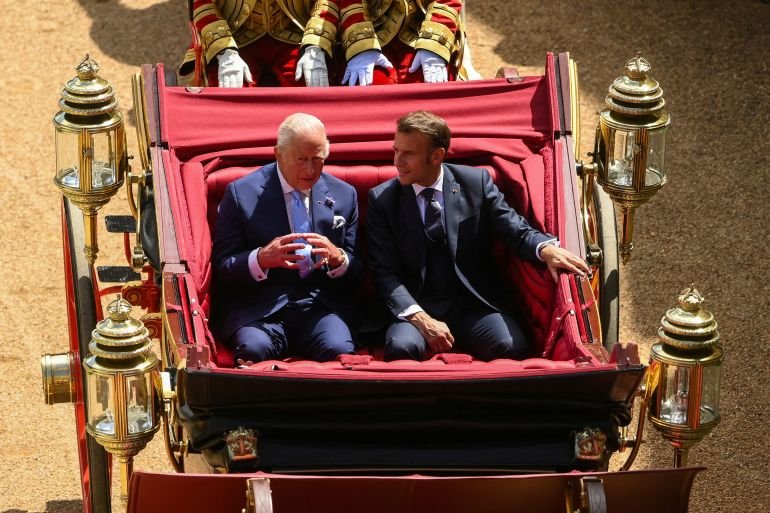 Britain's King Charles and French President Emmanuel Macron sit on a carriage as they arrive at Windsor Castle, in Windsor, Britain, July 8, 2025.